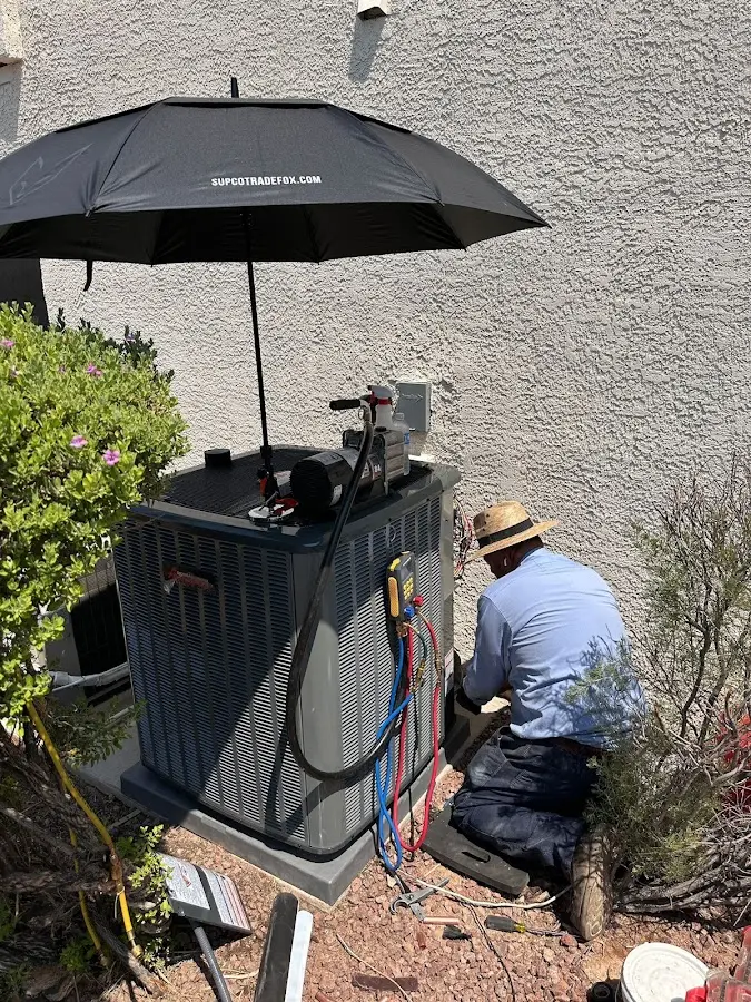 HVAC technician performing outdoor AC maintenance in West Des Moines